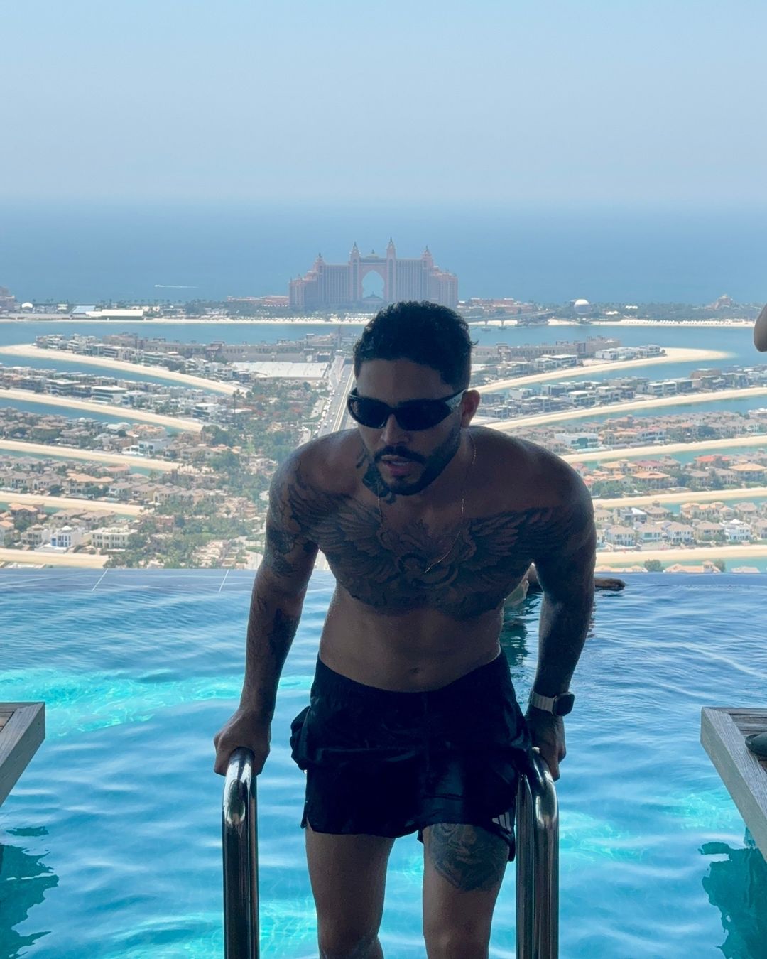 Pedro Silvestrini em piscina com vista para a Palm Jumeirah, Dubai